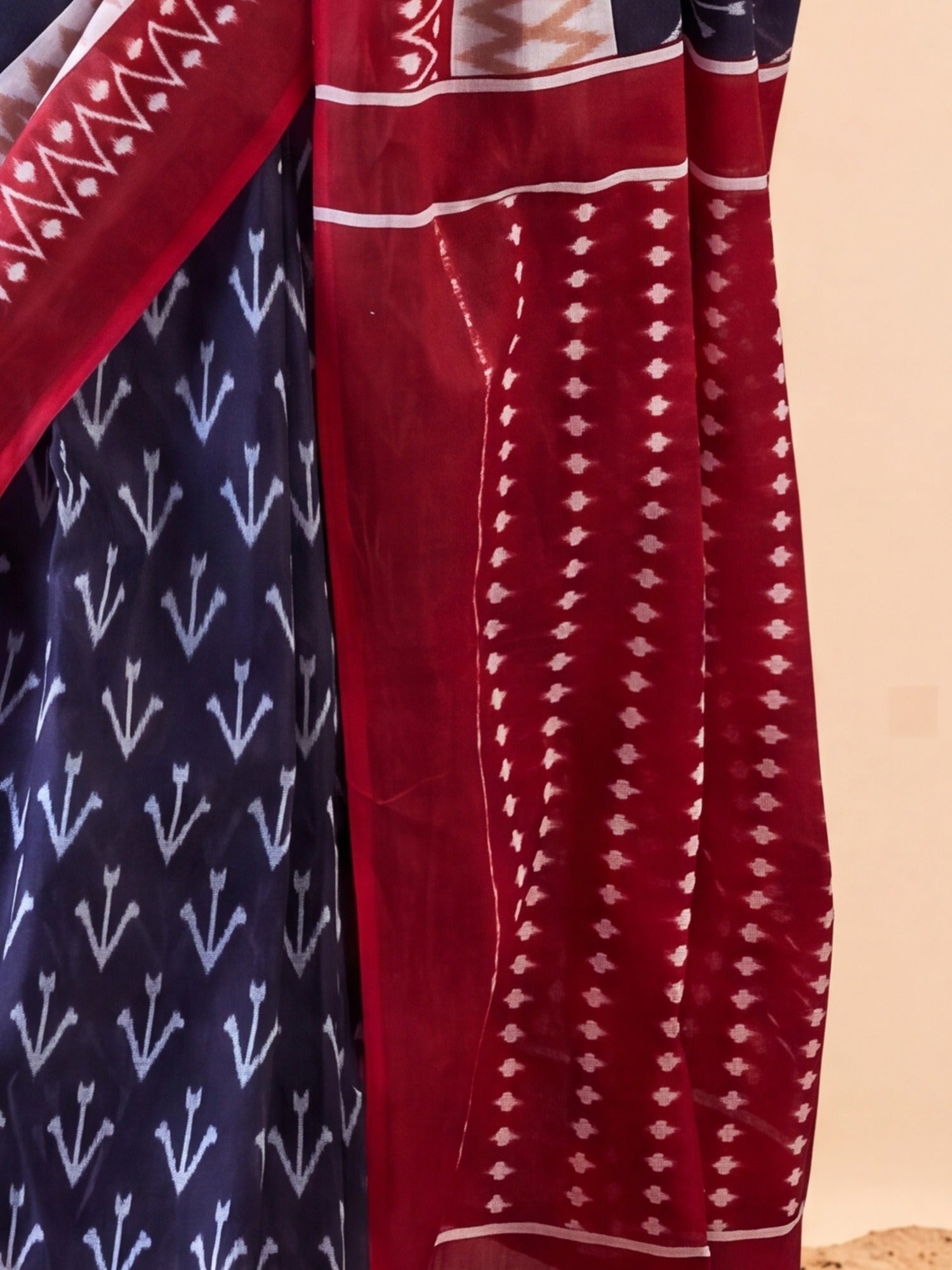 Pallu detail of navy blue cotton saree showing ikat resist-dyed pattern and printed border
