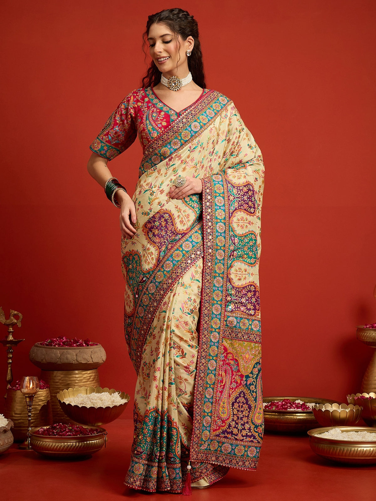 Woman wearing cream silk blend saree with traditional indian motif work and pink blouse