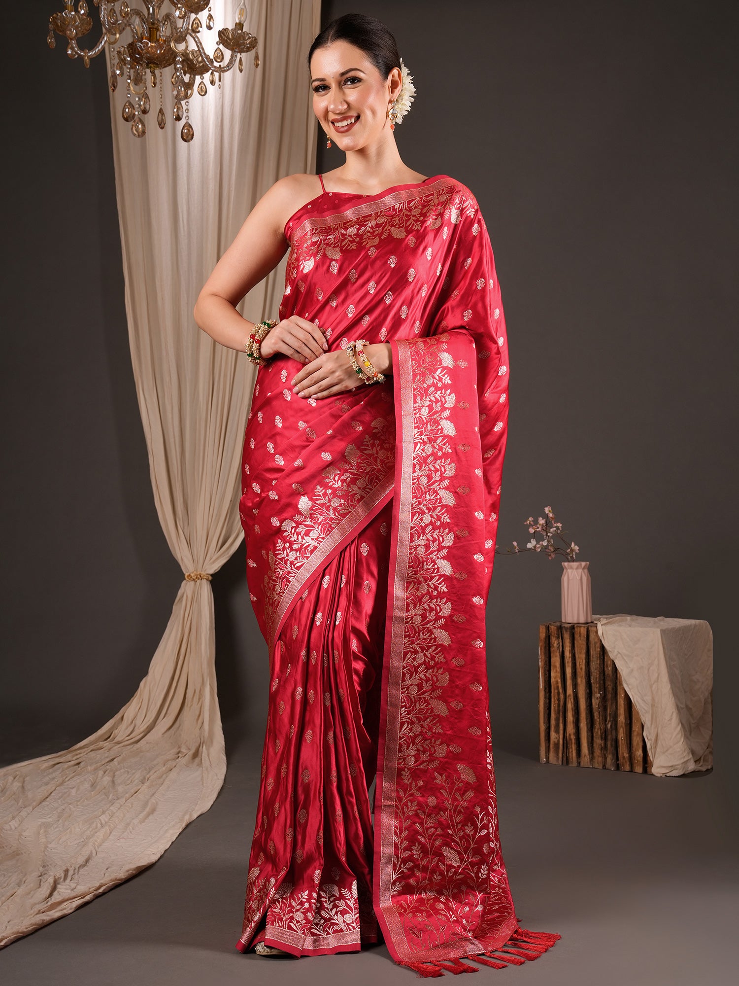 Woman wearing red silk blend saree with zari butta (metallic motif) work and red blouse