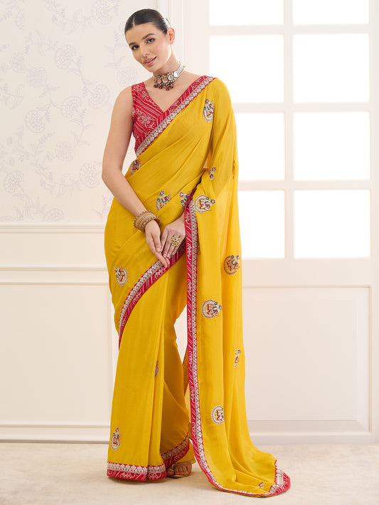 Woman wearing yellow chinnon saree with zari butta (metallic motif) work and red blouse