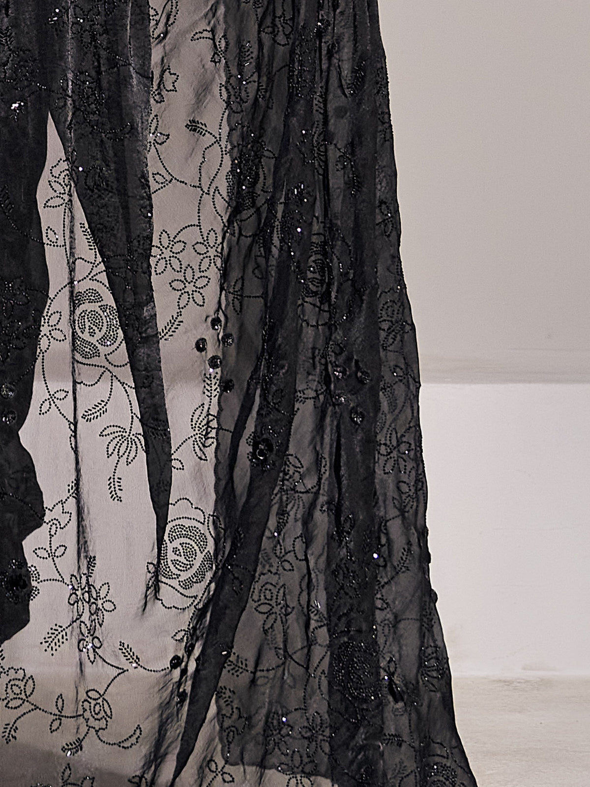 Pallu detail of black satin silk saree showing ornamented surface design and embellished border