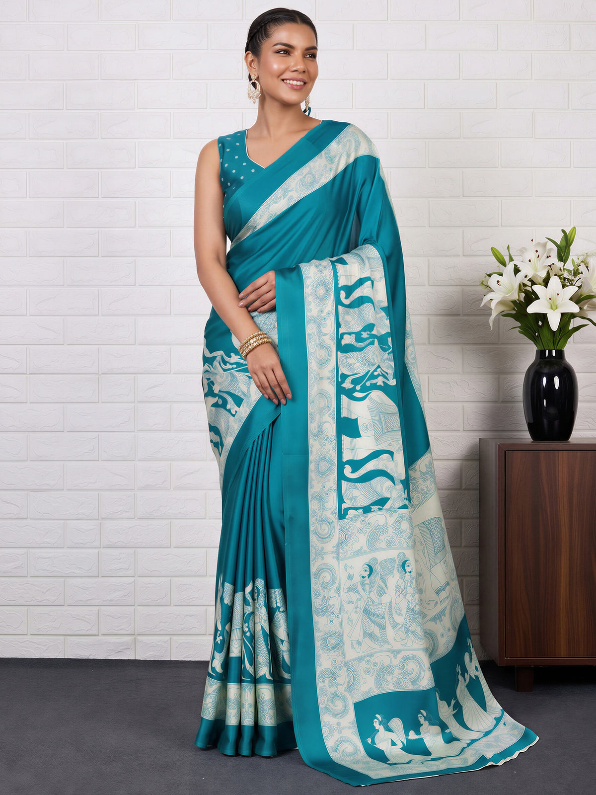 Woman wearing turquoise blue satin saree with kalamkari narrative motif work and turquoise blue blouse