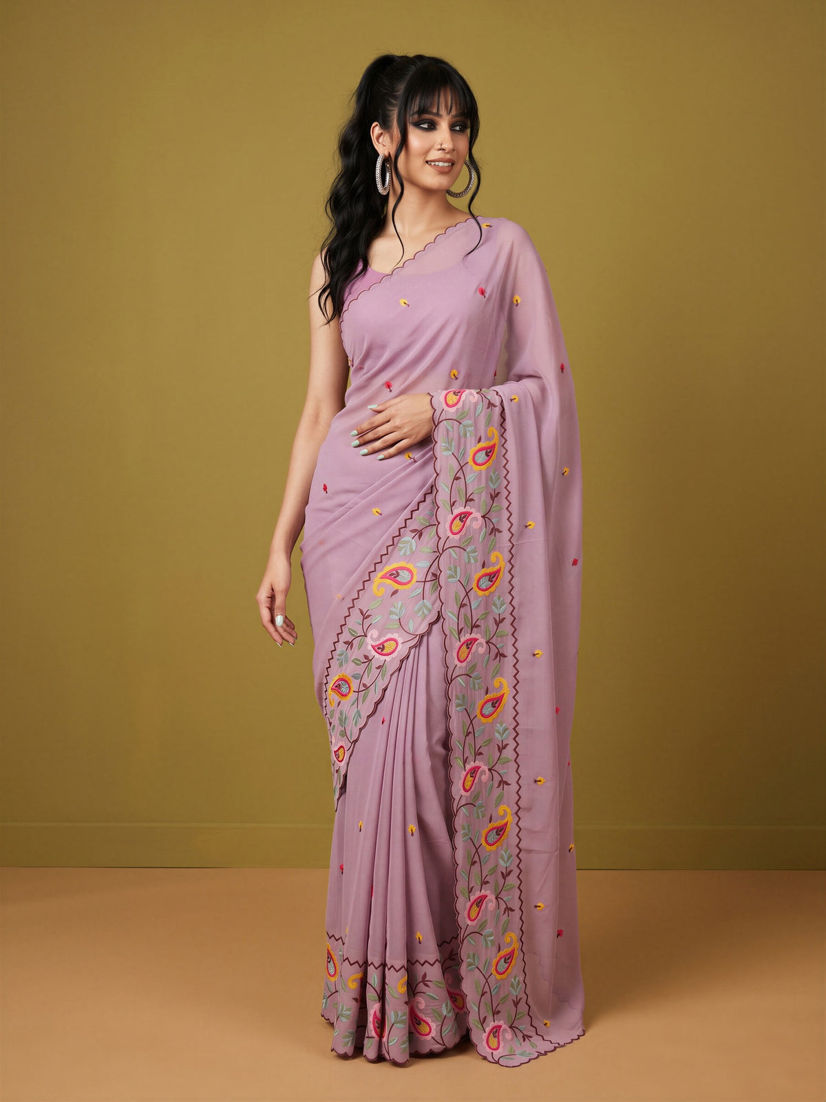 Woman wearing pink georgette saree with embroidered motif work and pink blouse