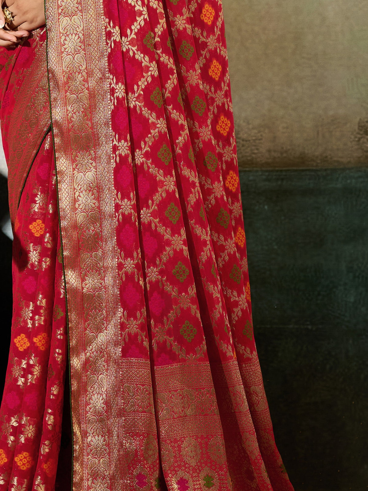 Pallu detail of red georgette saree showing woven motif design and zari border