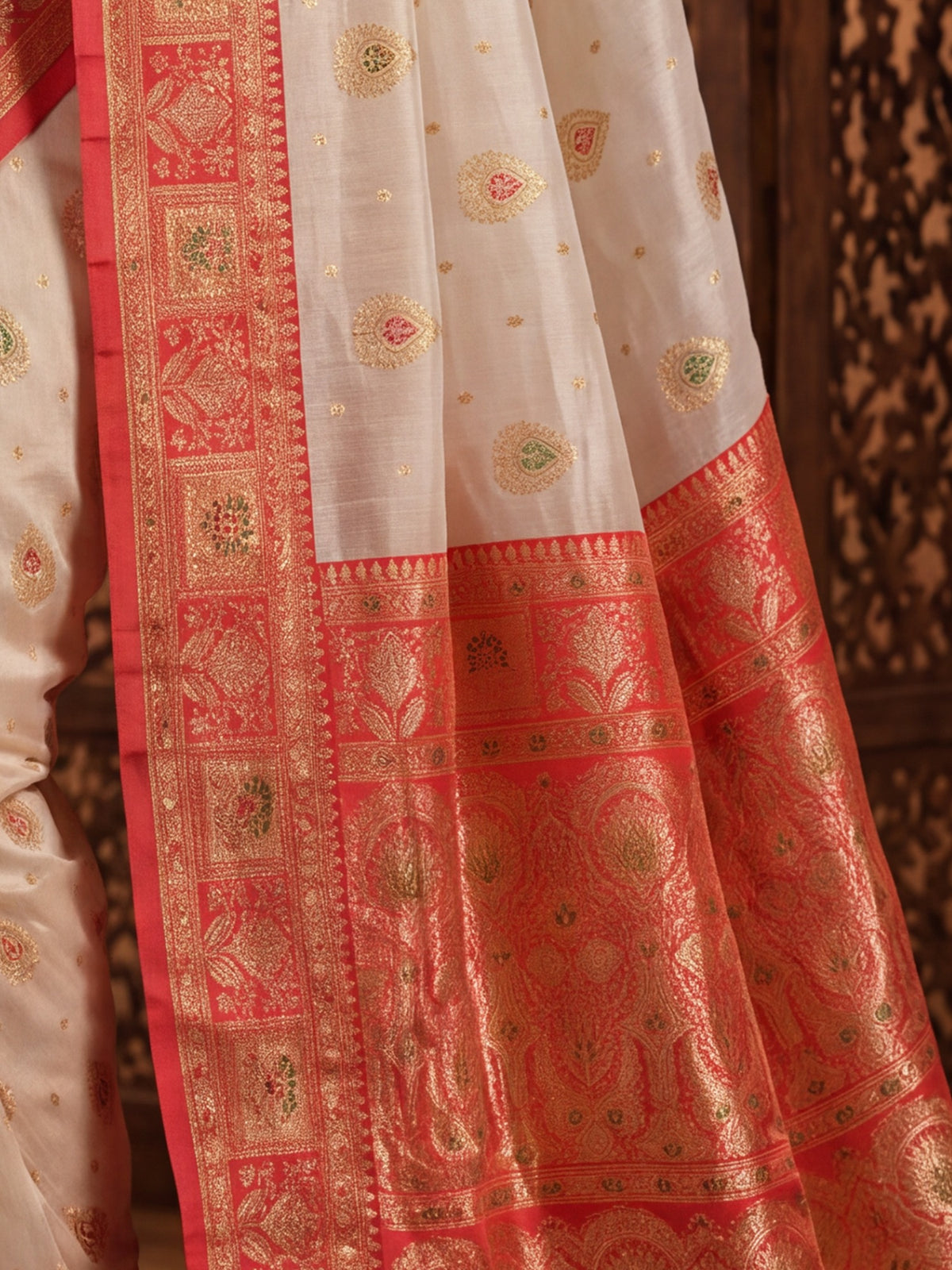 Pallu detail of white banarasi silk saree showing zari butta (metallic motif) work and zari border