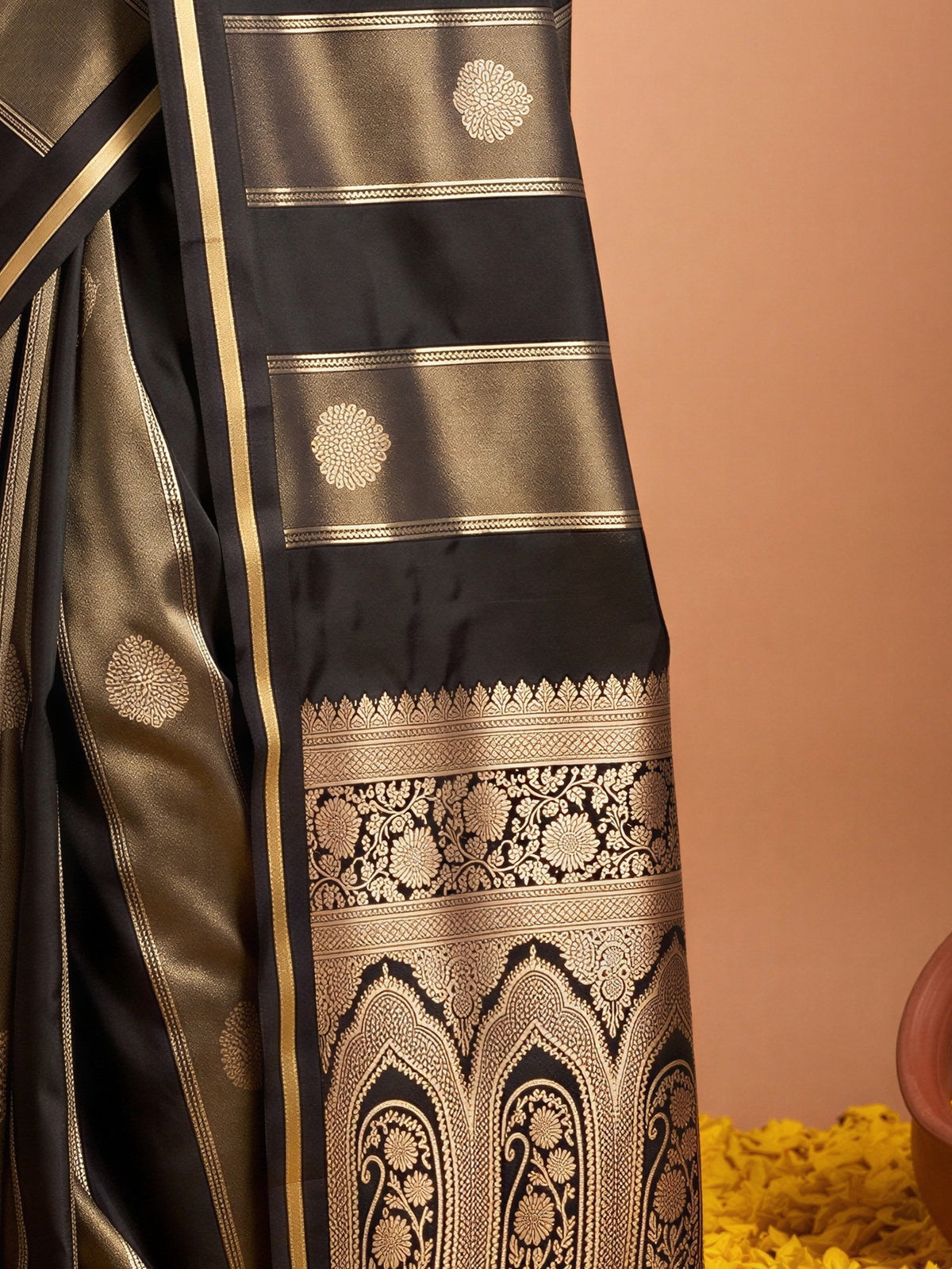 Pallu detail of black satin saree showing traditional indian motif work and zari border