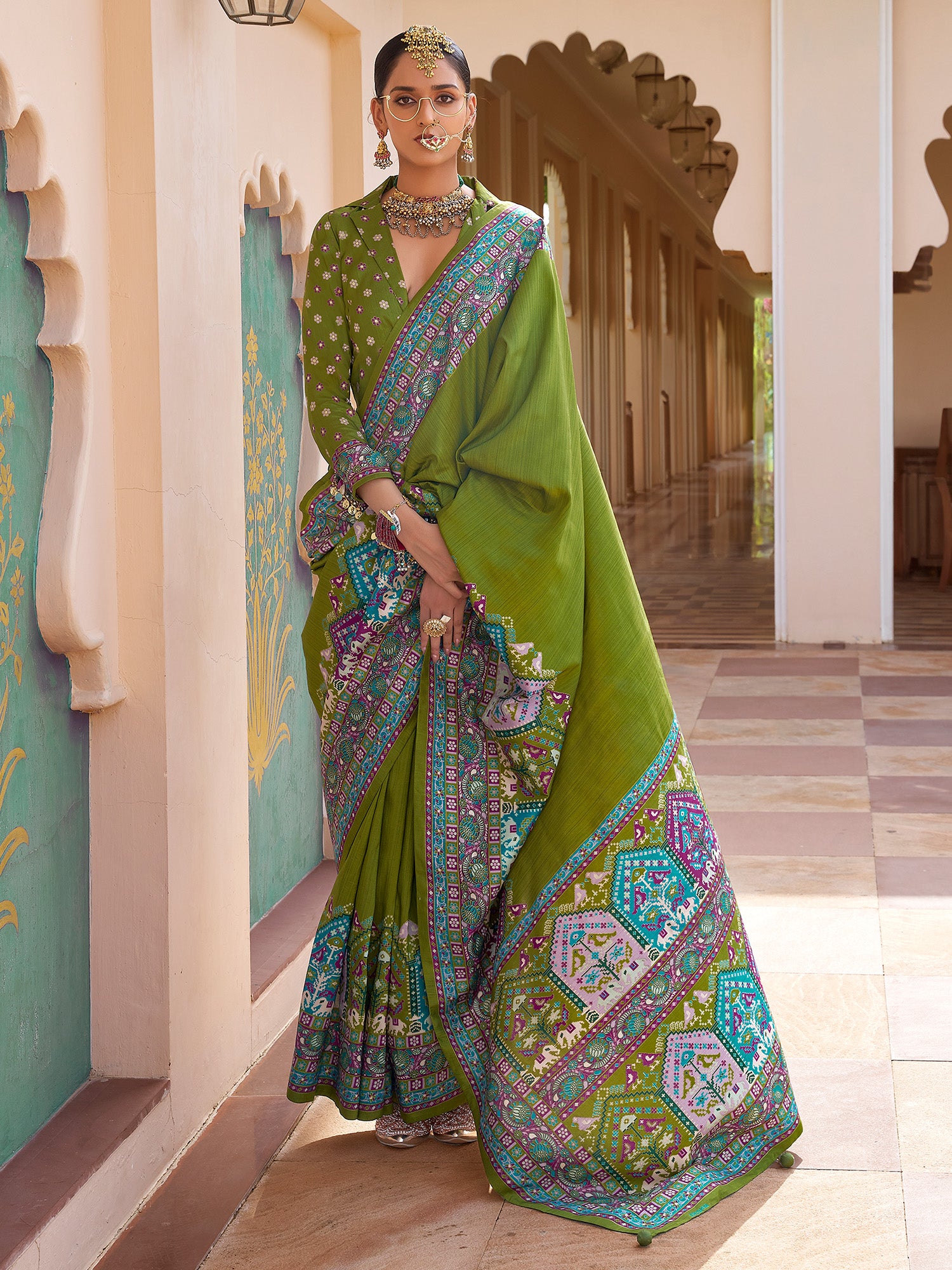 Woman wearing green silk blend saree with kalamkari narrative motif work and green blouse