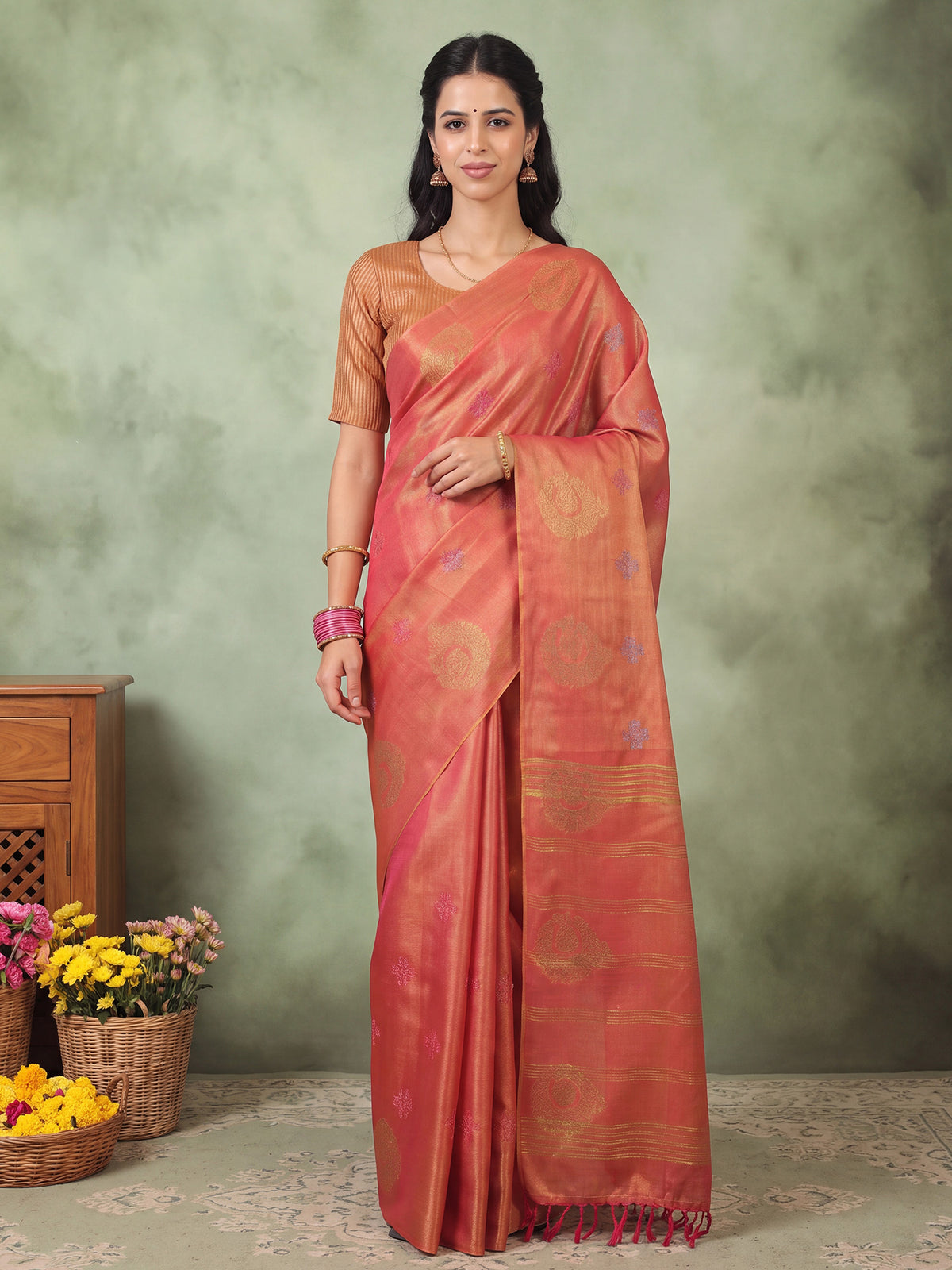 Woman wearing orange linen saree with traditional indian motif work and orange blouse