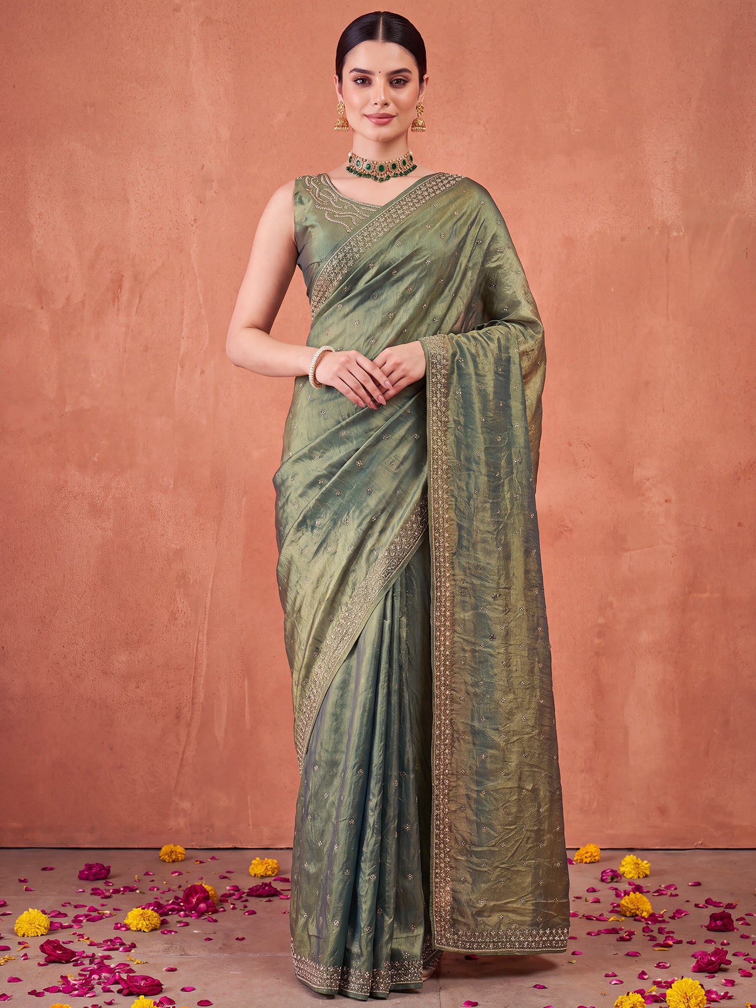 Woman wearing olive satin silk saree with ornamented surface design and olive blouse