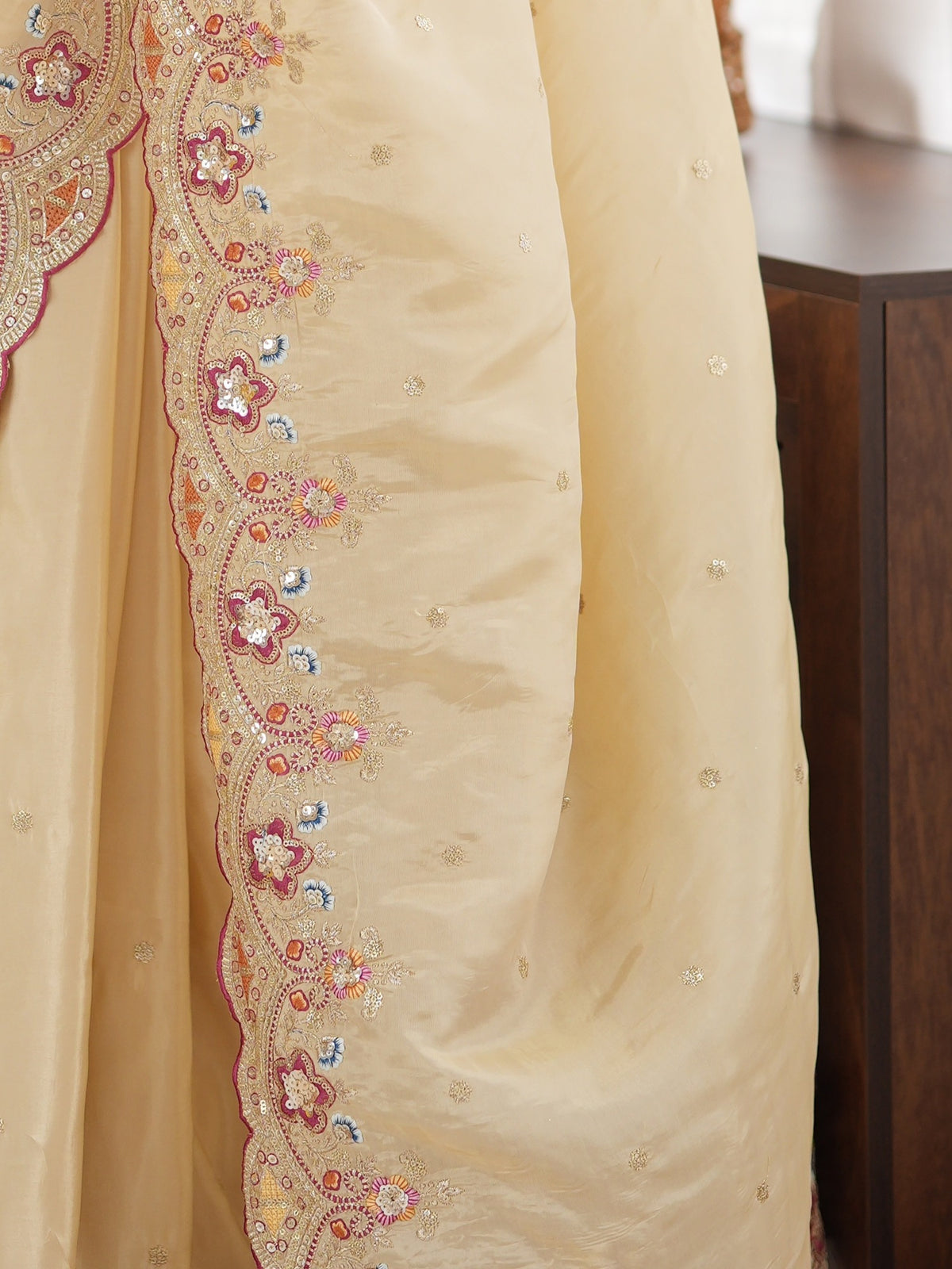 Pallu detail of off white satin saree showing ornamented surface design and scallop border