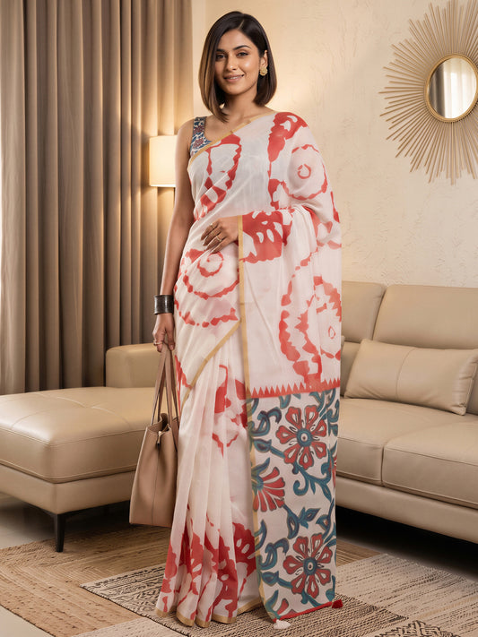 Woman wearing white cotton blend saree with shibori resist-dye pattern and coral blouse