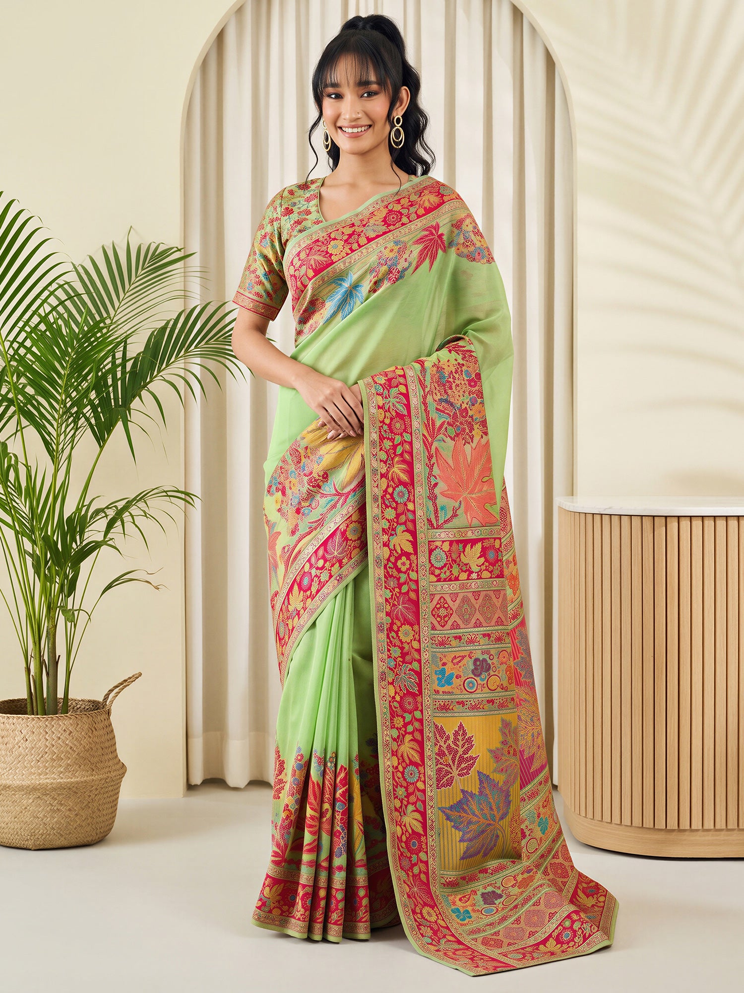 Woman wearing mint green pashmina silk saree with traditional indian motif work and mint green blouse