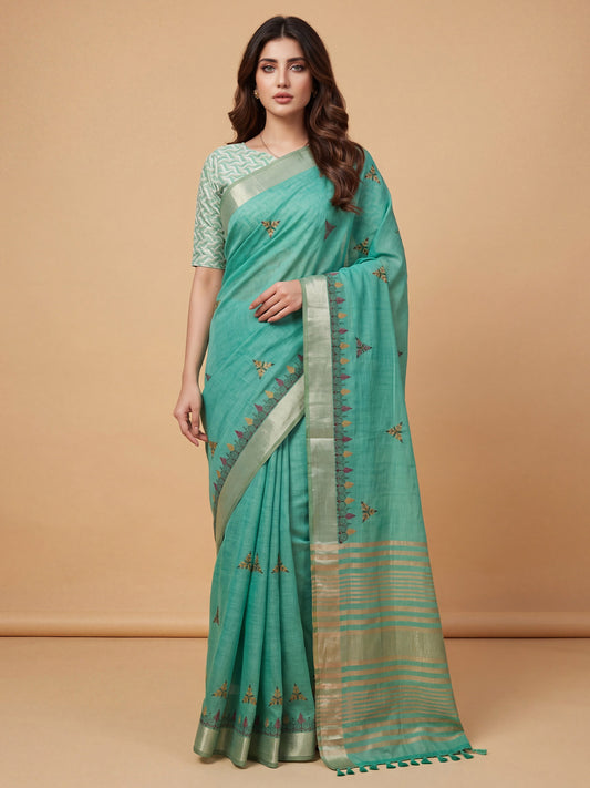 Woman wearing sea green cotton linen saree with embroidered motif work and sea green blouse