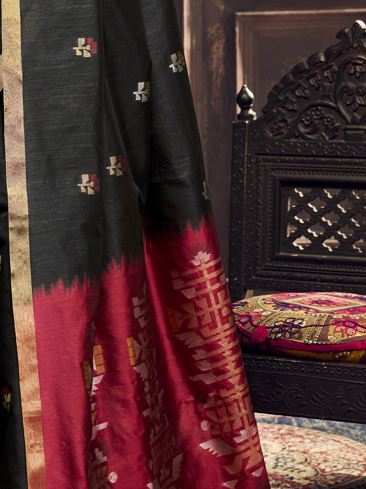 Pallu detail of black silk blend saree showing zari butta (metallic motif) work and zari border