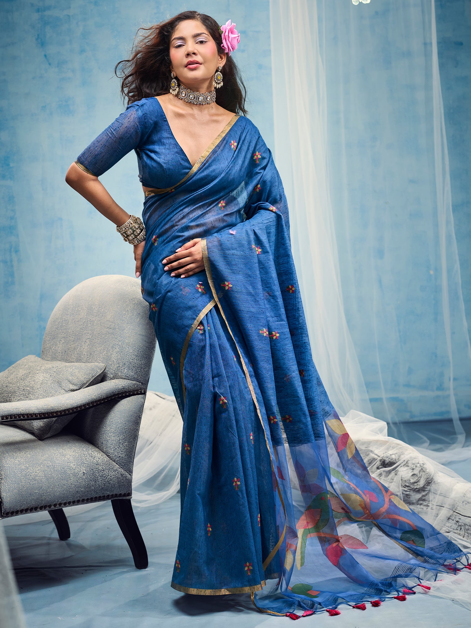 Woman wearing blue muga cotton saree with embroidered motif work and blue blouse