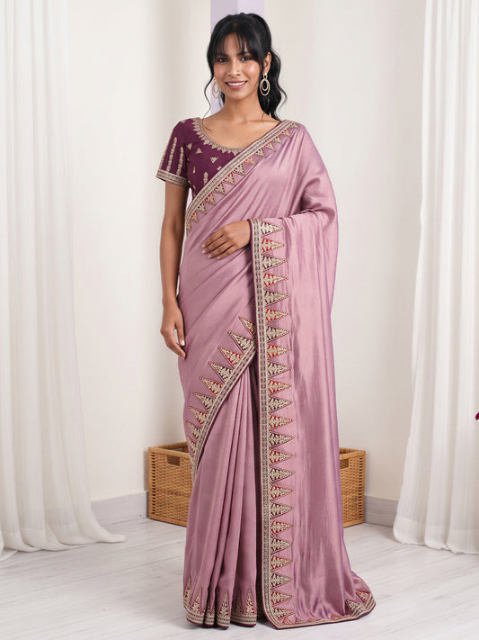 Woman wearing lavender vichitra silk saree with embroidered motif work and purple blouse