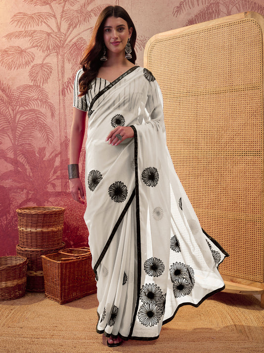 Woman wearing white georgette saree with ornamented surface design and white blouse