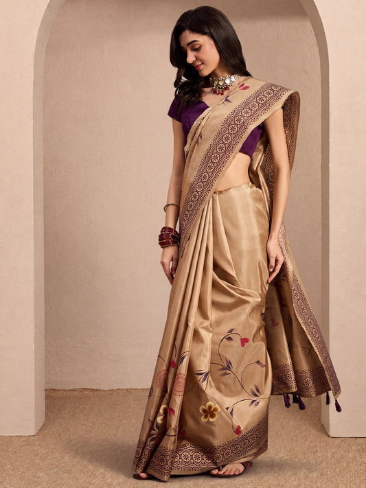 Woman wearing beige silk blend saree with hand-painted motif work and purple blouse