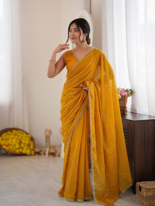 Woman wearing mustard georgette saree with ornamented surface design and mustard blouse