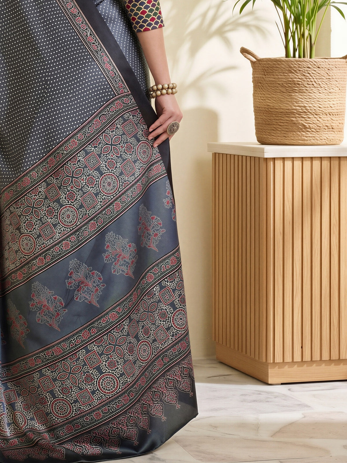 Pallu detail of charcoal grey satin saree showing polka dot pattern and printed border