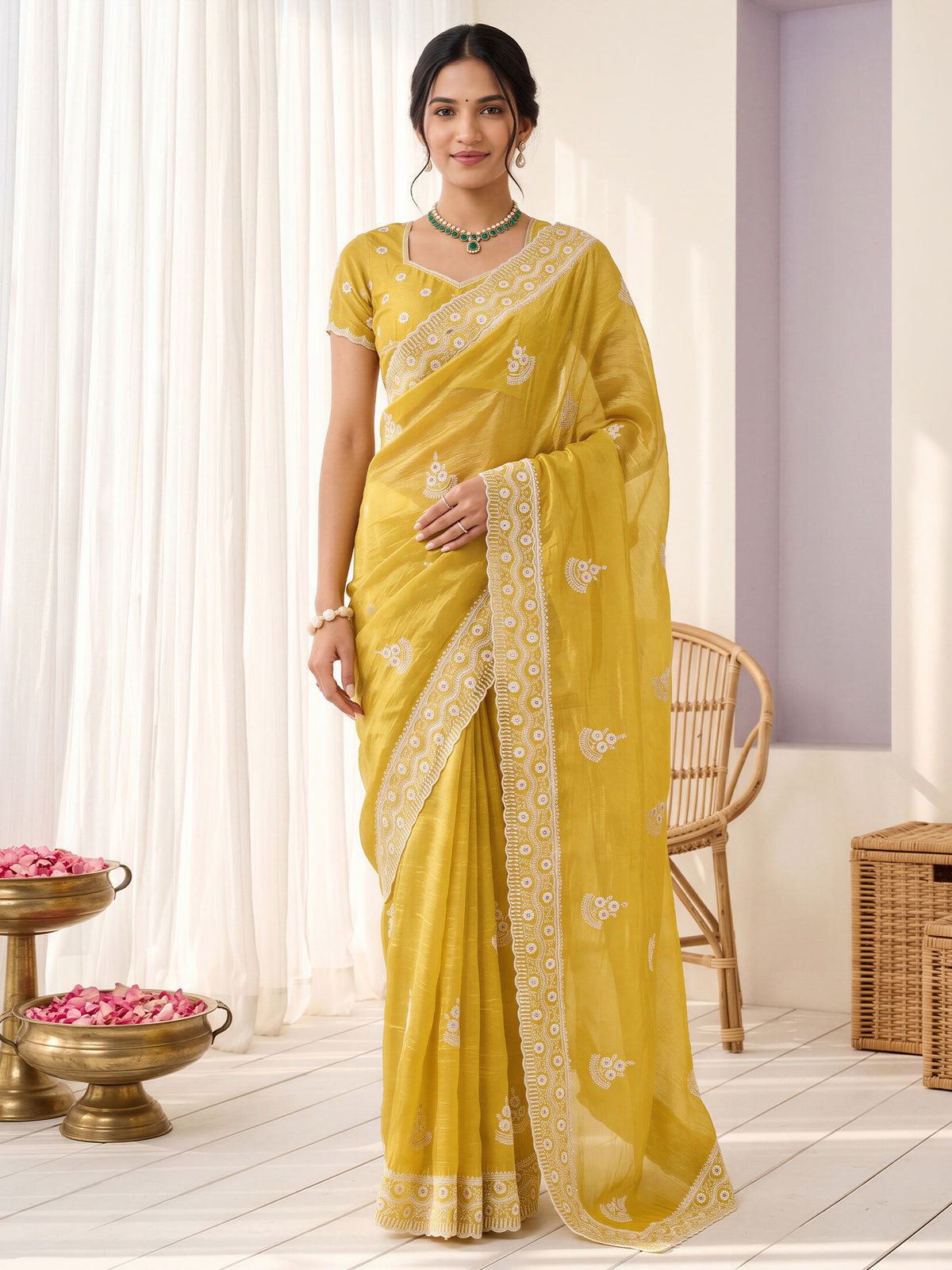Woman wearing yellow paper silk saree with ornamented surface design and yellow blouse