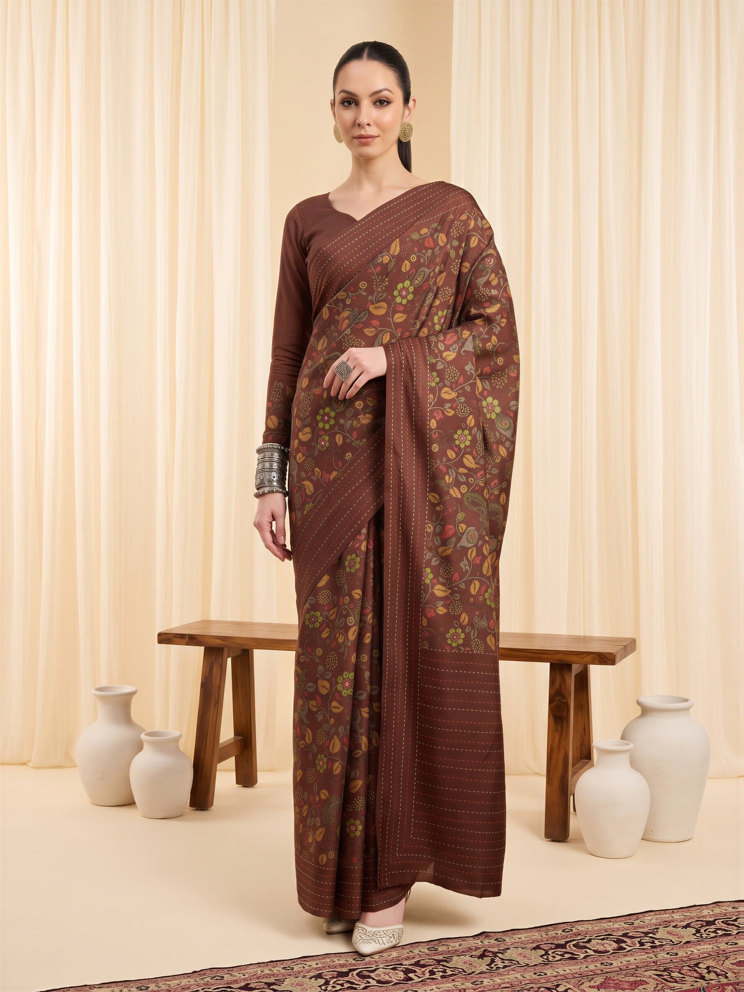 Woman wearing brown silk blend saree with kalamkari narrative motif work and brown blouse