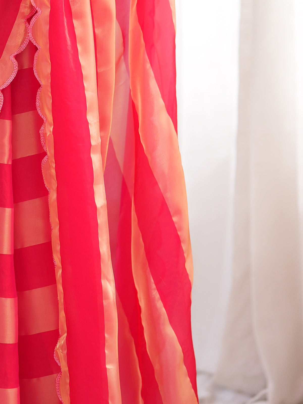 Pallu detail of pink satin saree showing striped pattern design and embroidered border