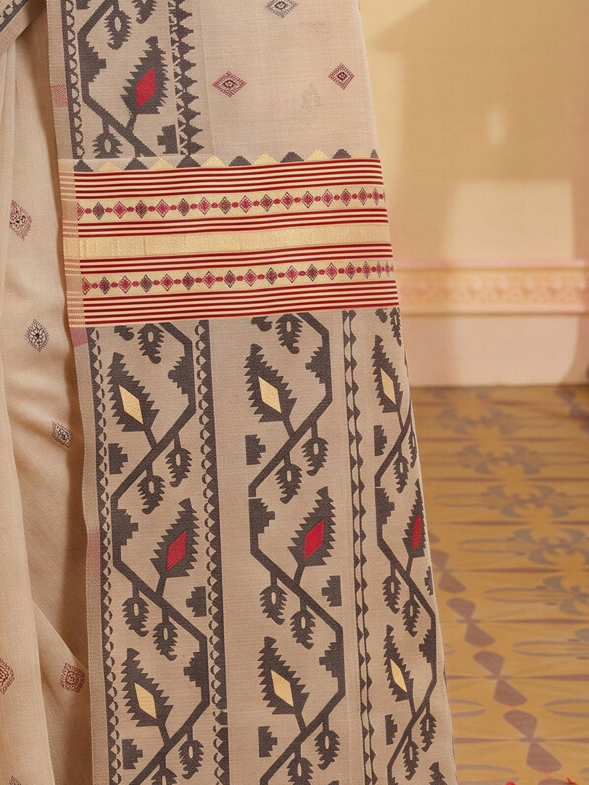 Pallu detail of beige linen saree showing woven motif design and woven design border