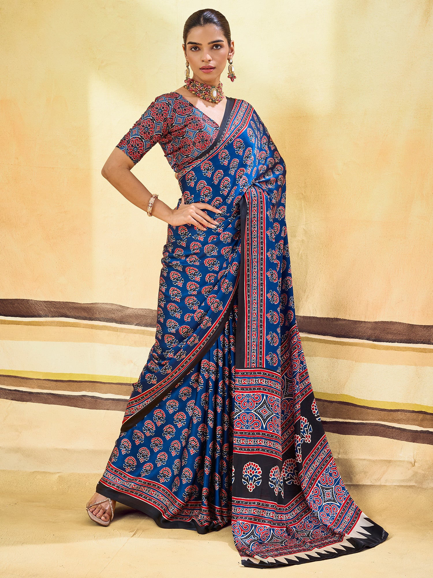 Woman wearing blue satin saree with ajrak block-print motif work and red blouse