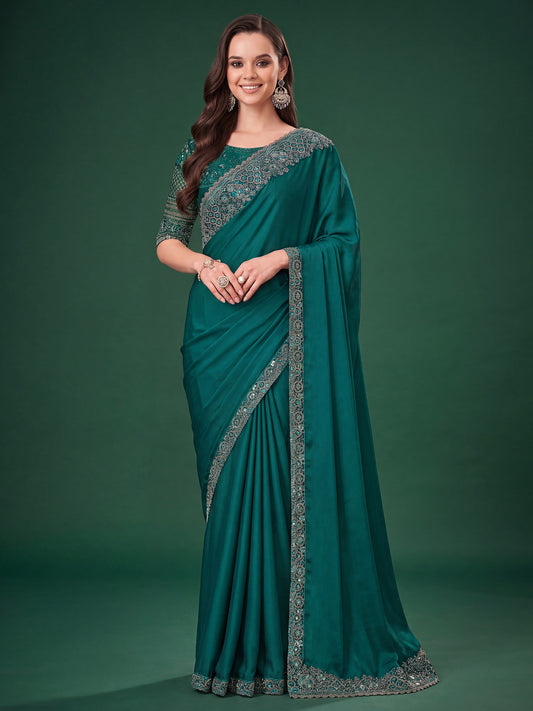 Woman wearing teal green satin silk saree with embroidered motif work and teal green blouse