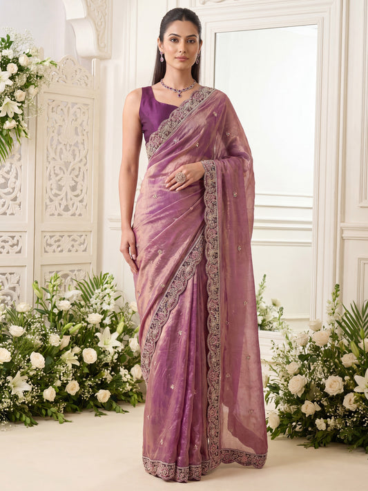 Woman wearing purple satin saree with ornamented surface design and wine blouse