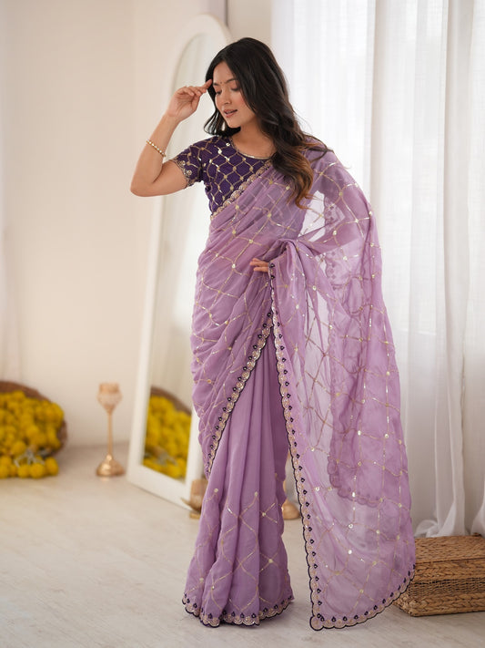 Woman wearing lavender georgette saree with ornamented surface design and purple blouse