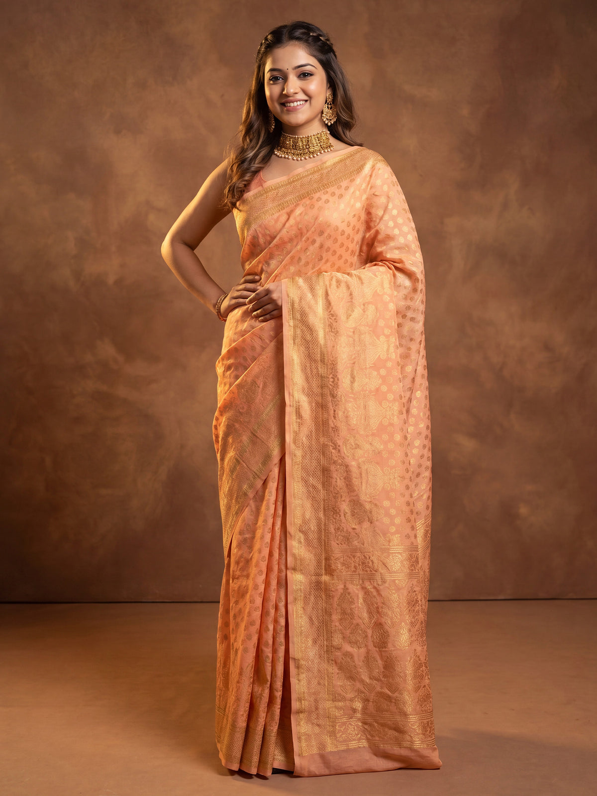 Woman wearing orange silk blend saree with zari butta (metallic motif) work and orange blouse