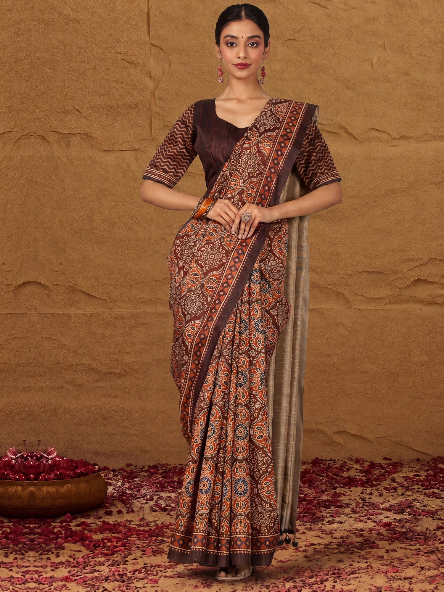 Woman wearing brown silk blend saree with traditional indian motif work and brown blouse