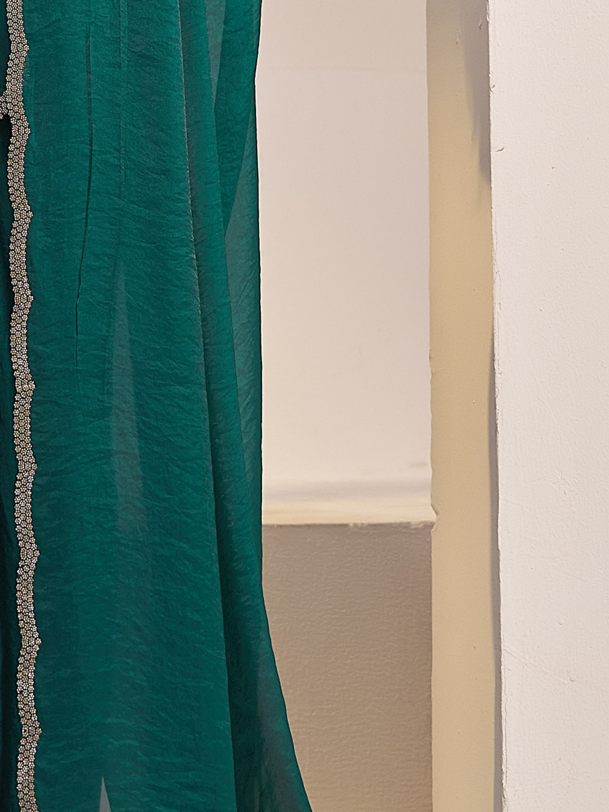 Pallu detail of teal green satin silk saree showing clean solid-tone finish and embellished border