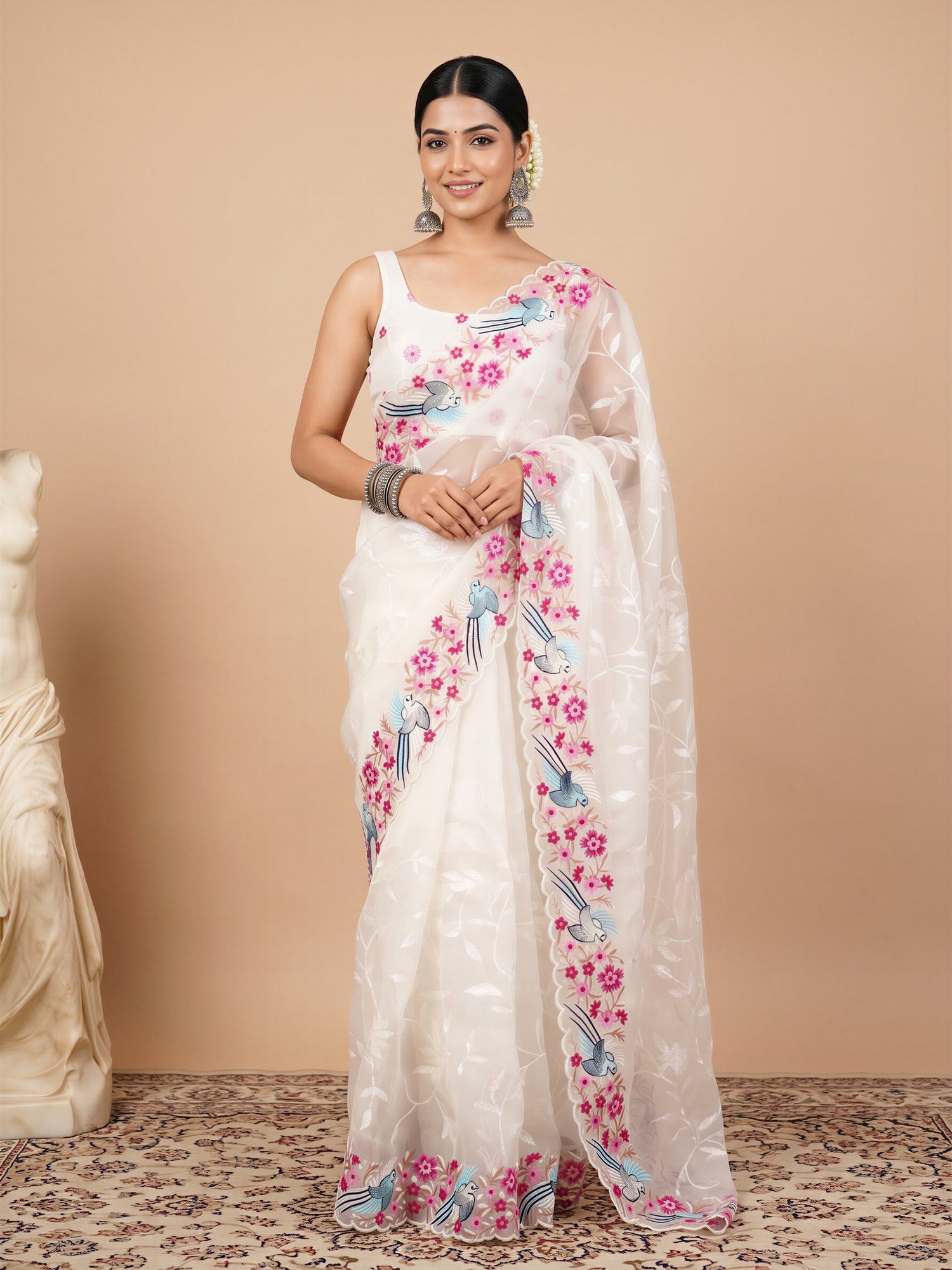 Woman wearing white organza saree with embroidered motif work and white blouse
