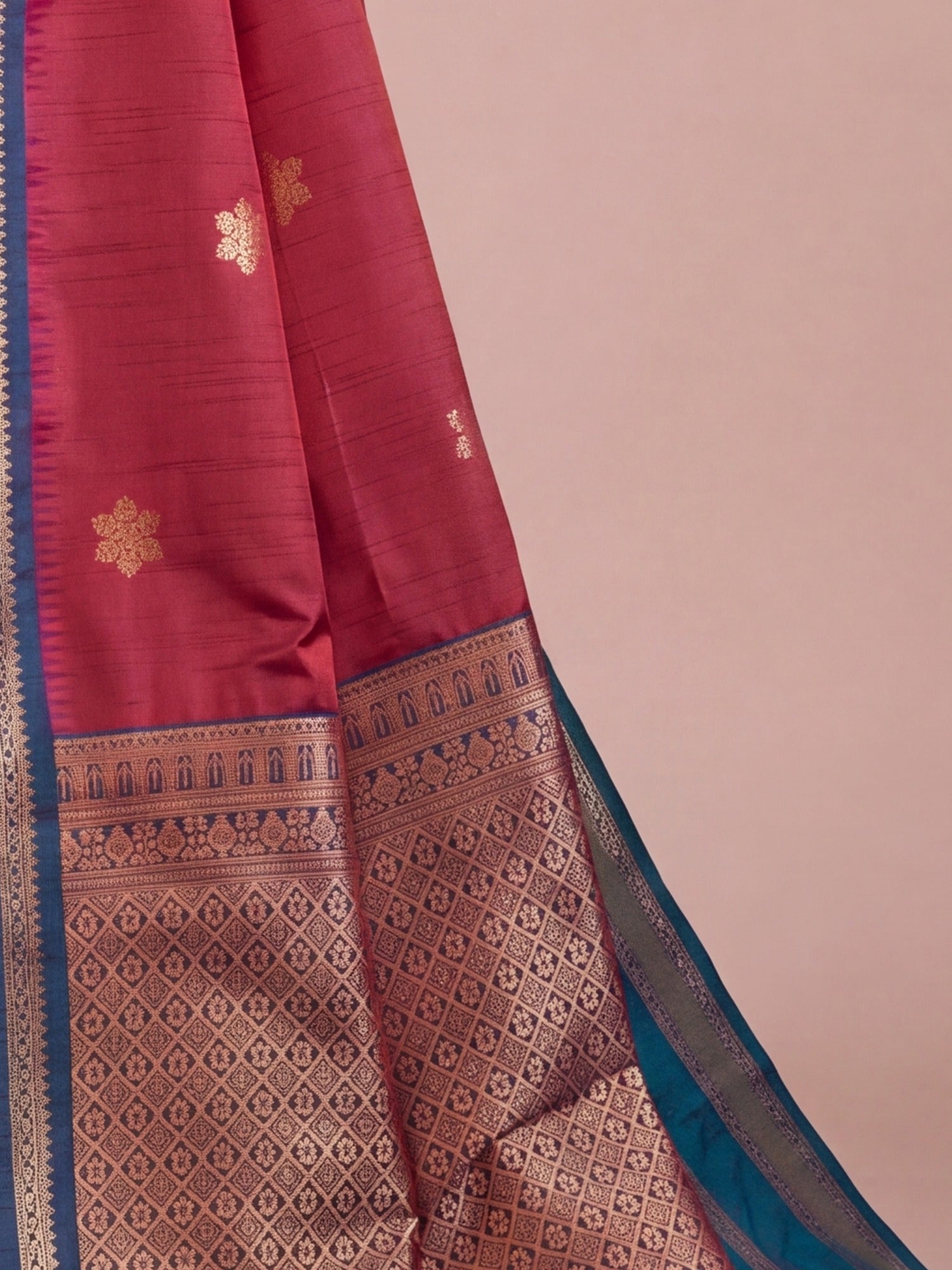 Pallu detail of maroon tussar silk saree showing traditional indian motif work and zari border