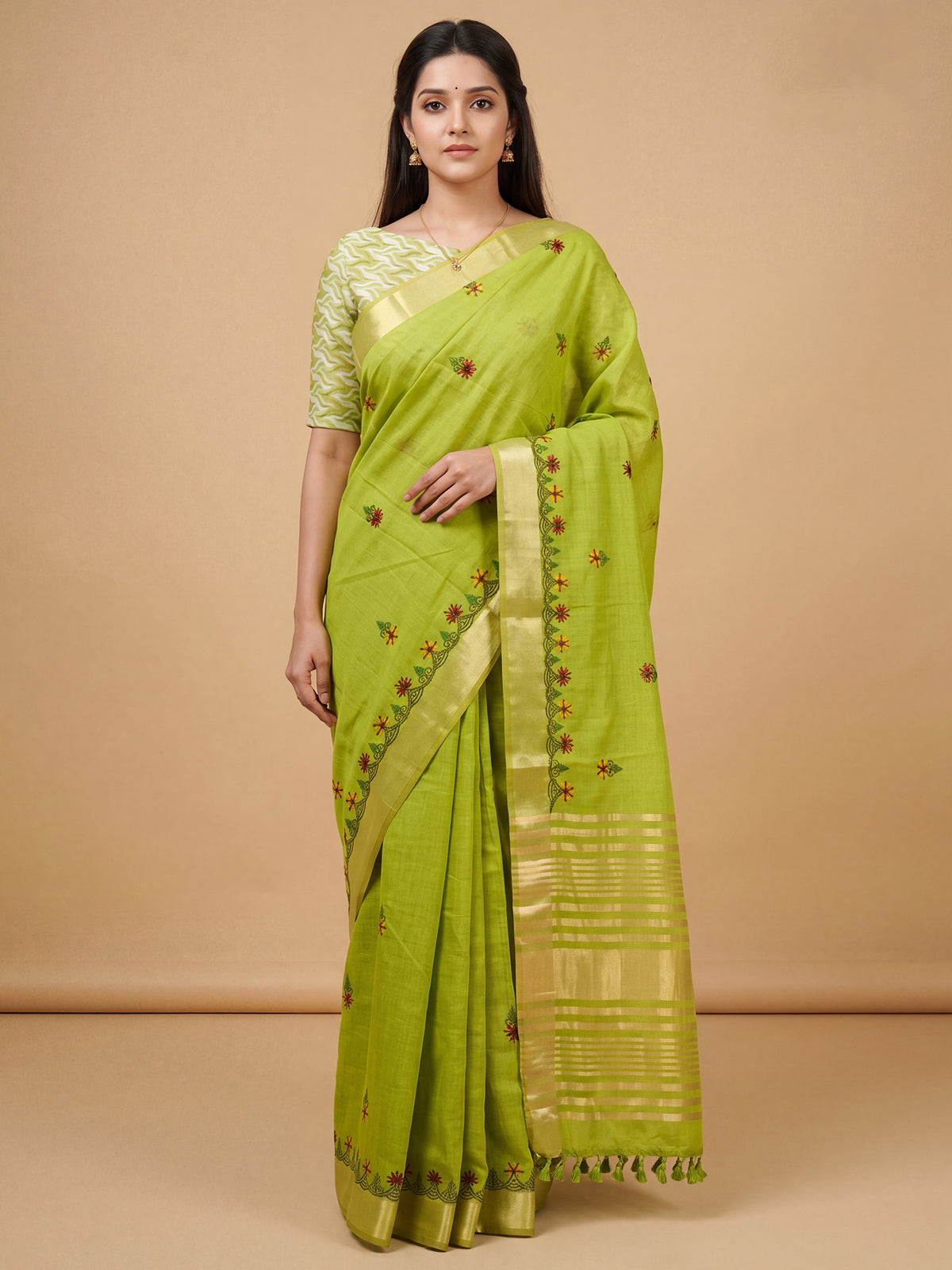 Woman wearing lime green cotton linen saree with embroidered motif work and lime green blouse