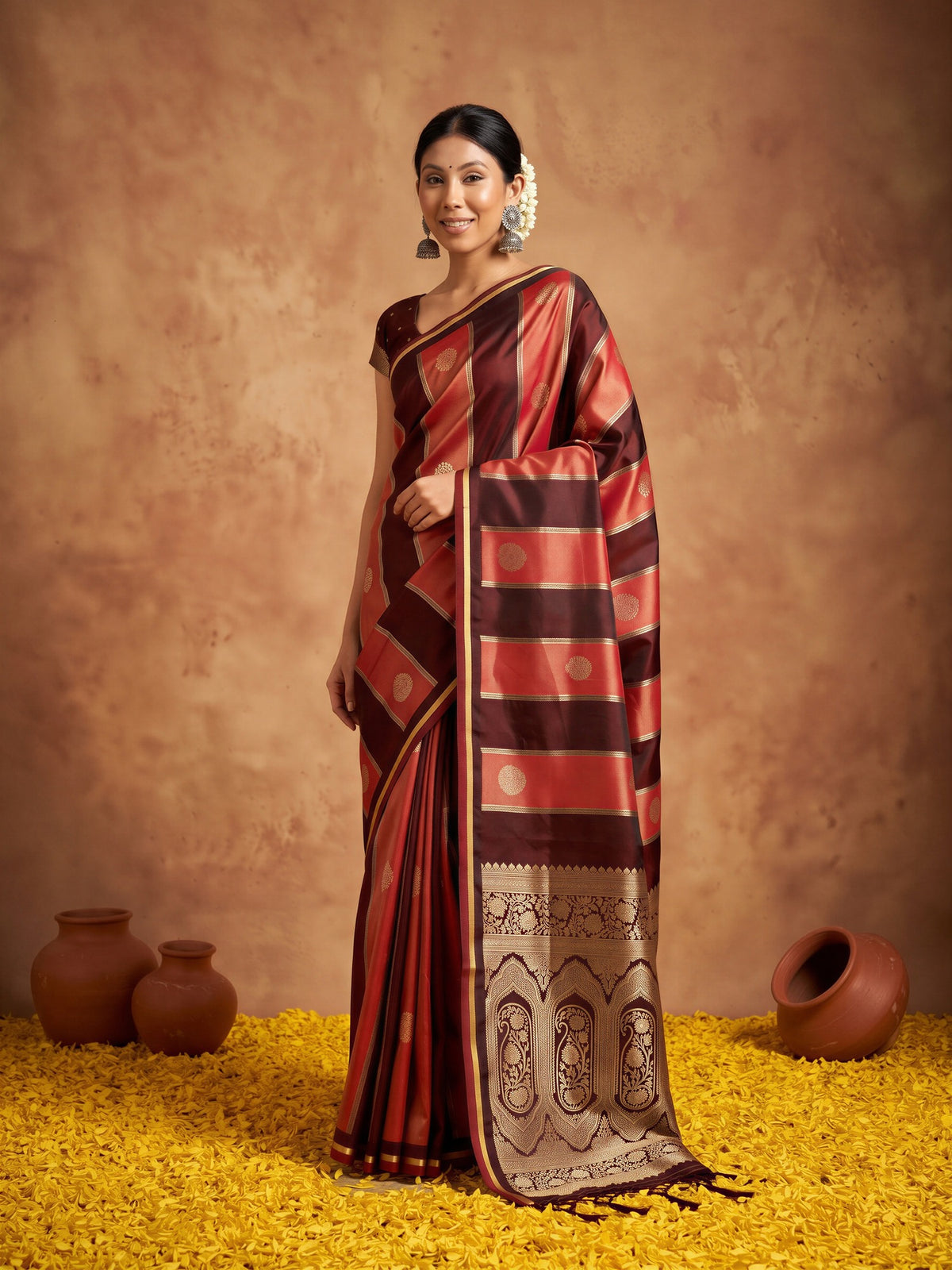 Woman wearing maroon satin saree with traditional indian motif work and maroon blouse
