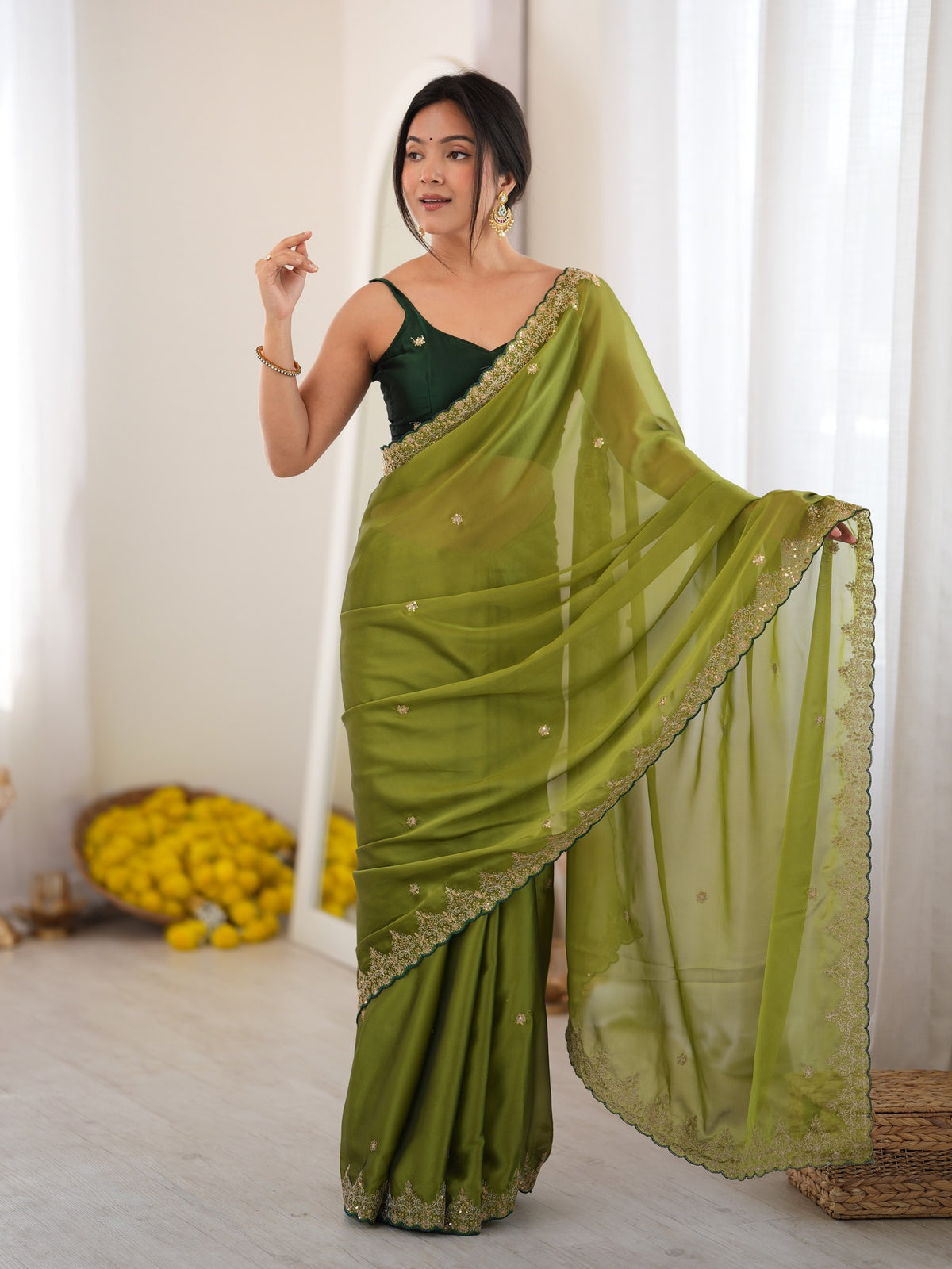 Woman wearing olive georgette saree with ornamented surface design and green blouse