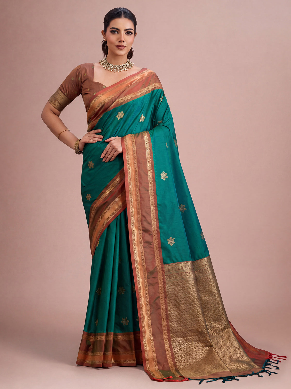 Woman wearing teal green tussar silk saree with traditional indian motif work and brown blouse