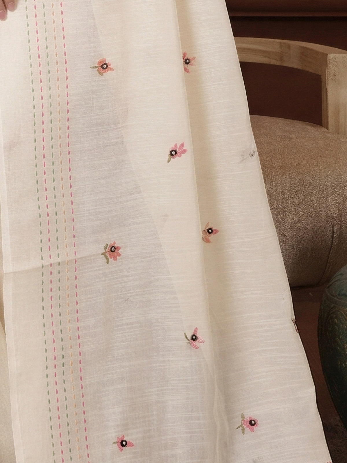 Pallu detail of cream linen saree showing embroidered motif work and embroidered border