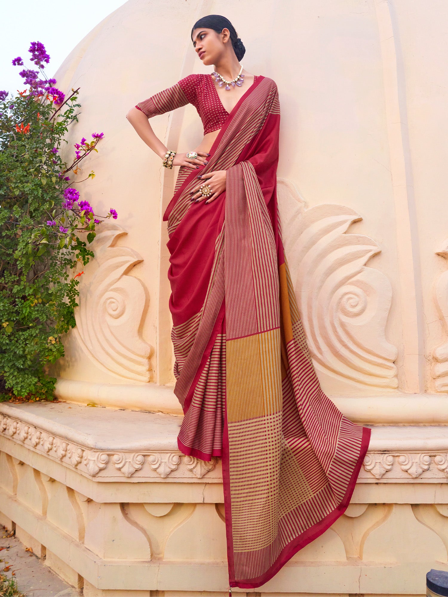 Woman wearing pink silk blend saree with striped pattern design and pink blouse