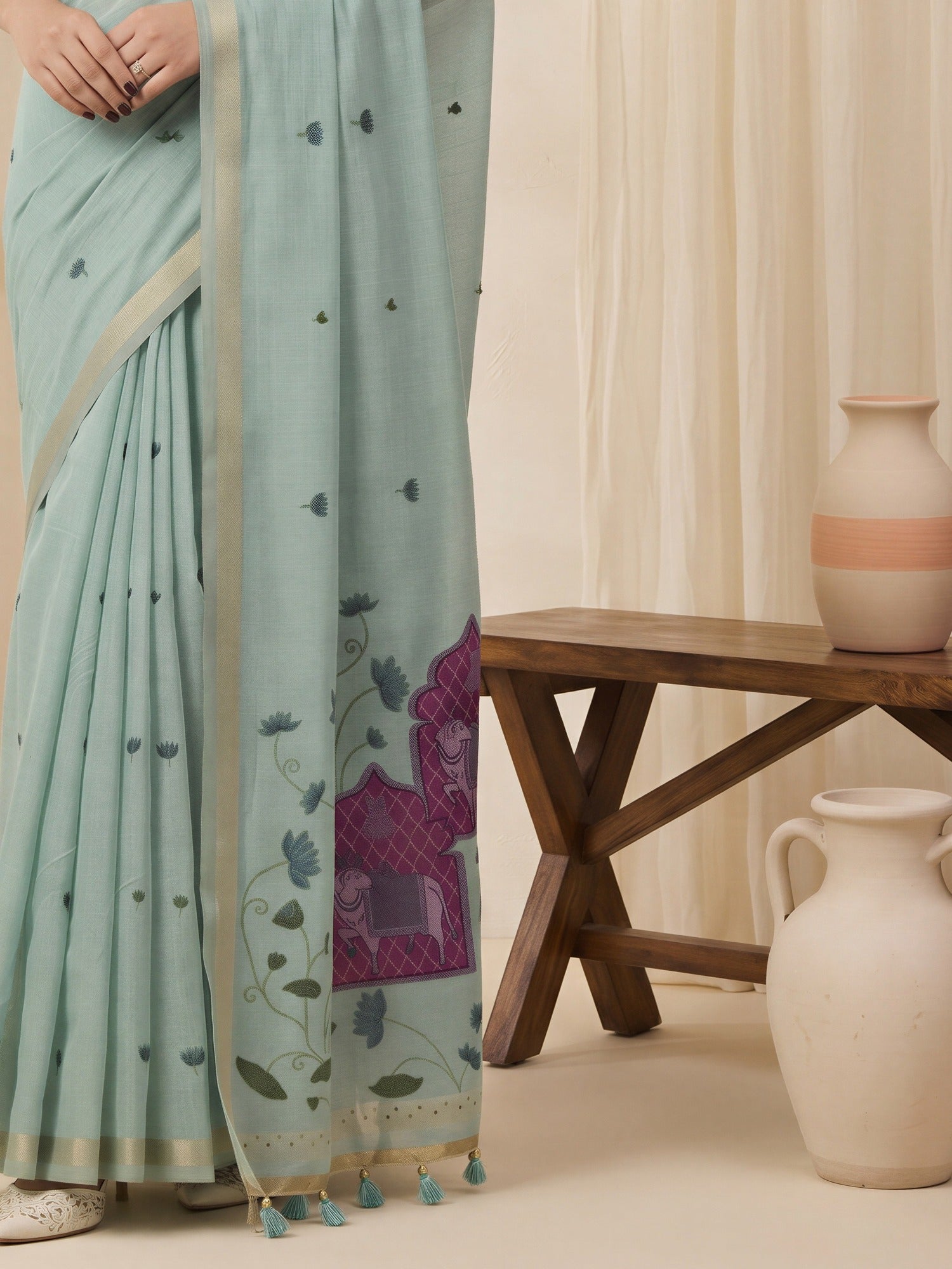 Pallu detail of teal blue pure cotton saree showing traditional indian motif work and solid border