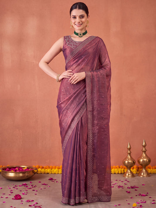 Woman wearing mauve satin silk saree with ornamented surface design and mauve blouse