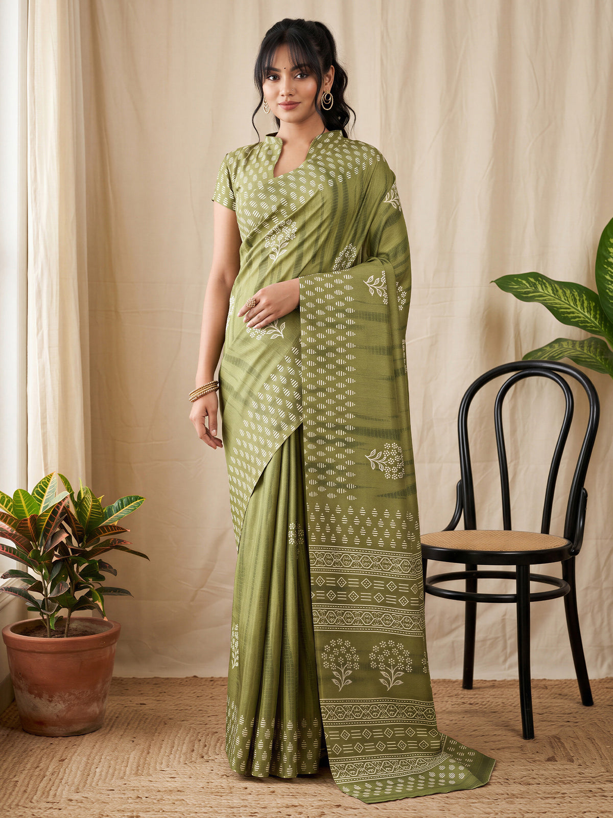 Woman wearing olive cotton blend saree with shibori resist-dye pattern and olive blouse