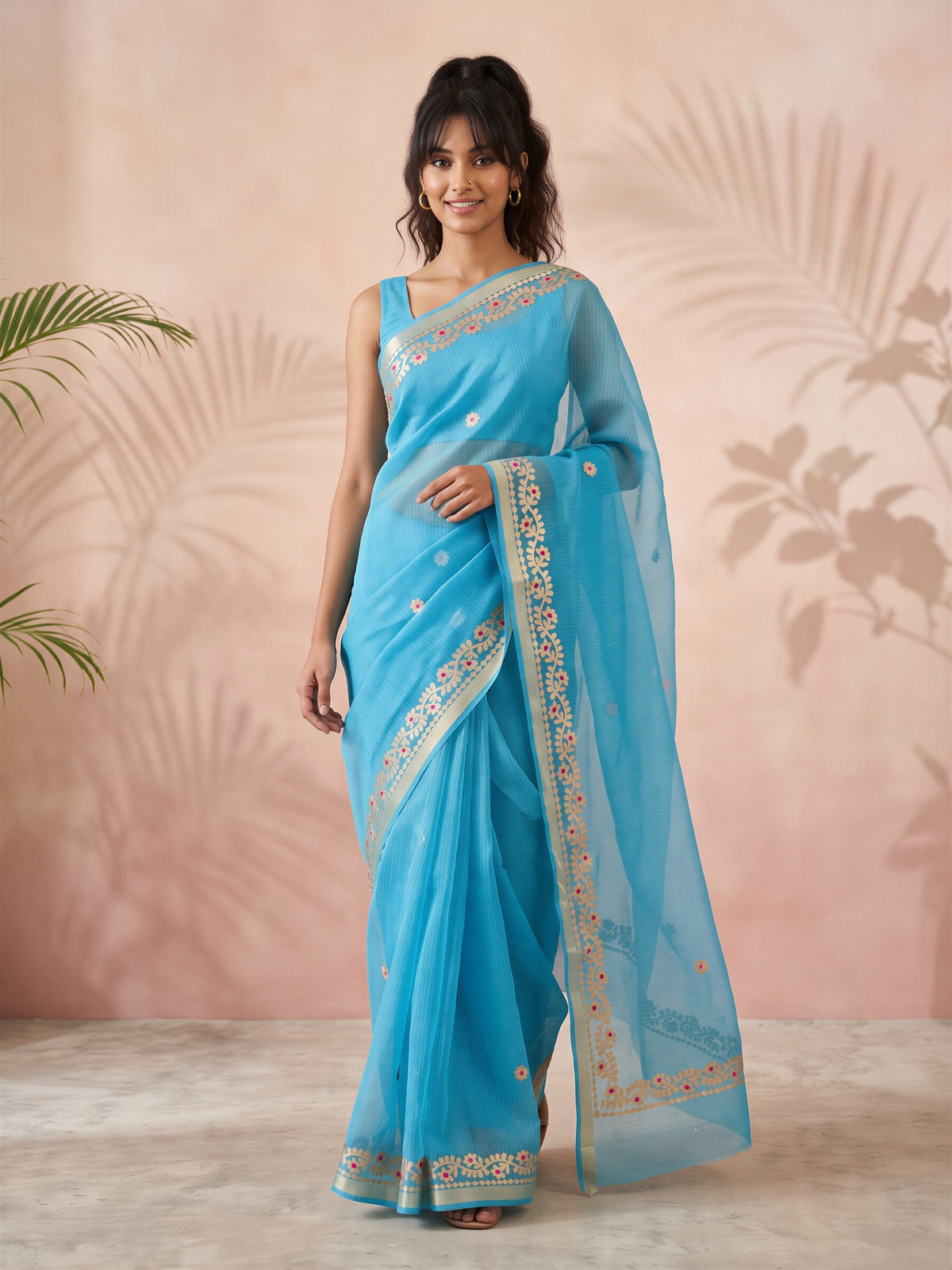 Woman wearing turquoise blue kota doria cotton saree with ornamented surface design and turquoise blue blouse