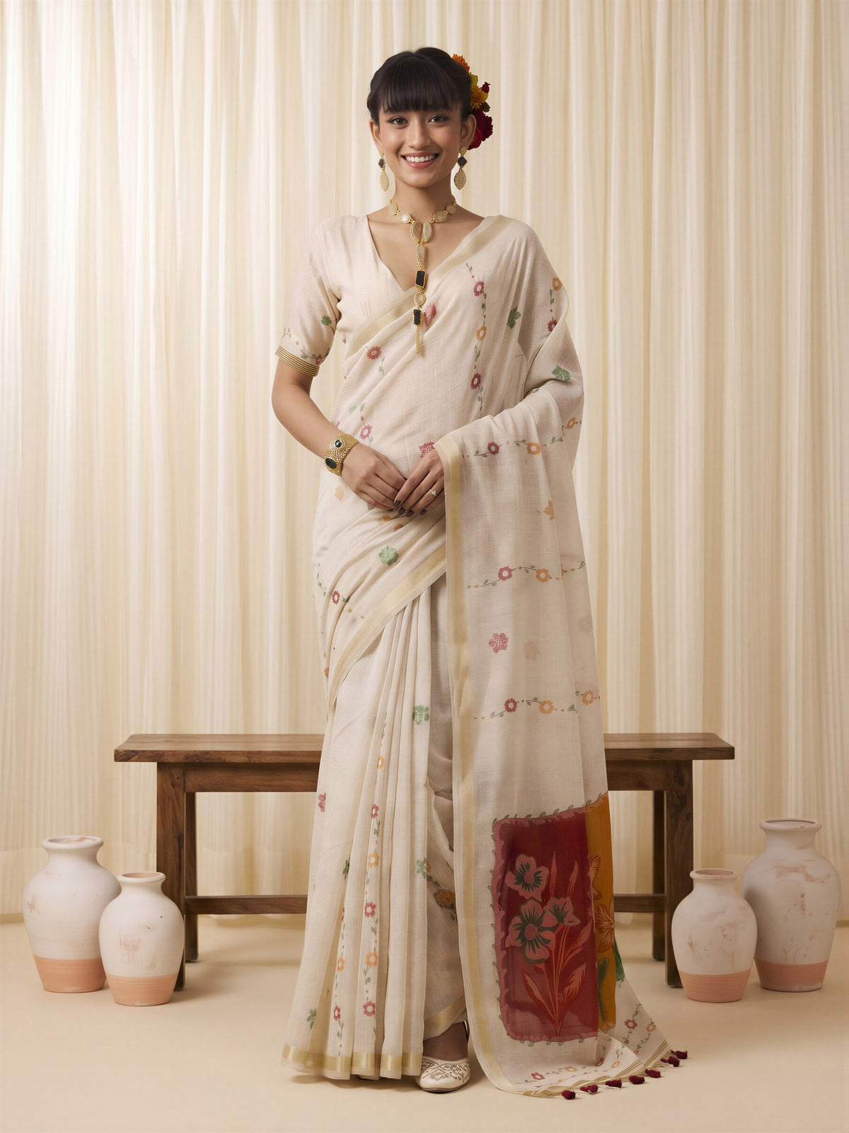 Woman wearing off white cotton blend saree with traditional indian motif work and off white blouse