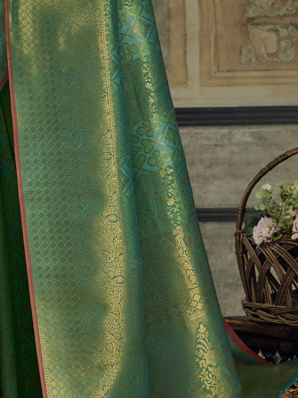 Pallu detail of teal green pure silk saree showing woven motif design and zari border