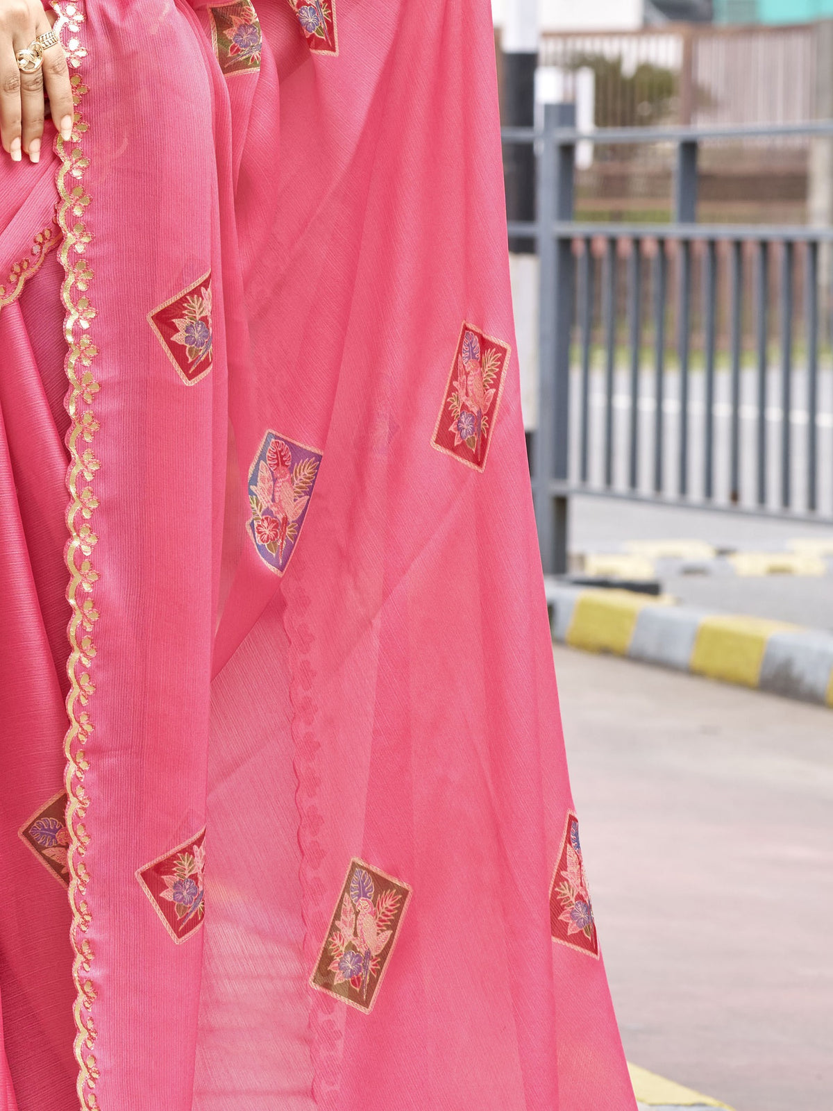 Pallu detail of peach chiffon saree showing metallic foil print work and embellished border